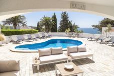 Heated swimming pool with deckchairs and relaxation area facing the ocean